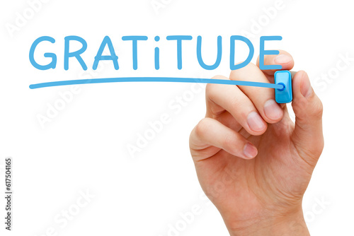 Hand writing Gratitude with blue marker on transparent wipe board.