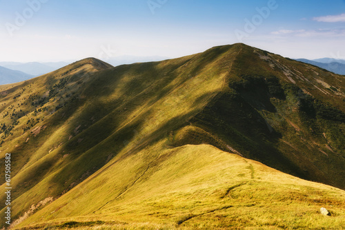Amazing landscape scenic mountains in summer. View of light and afternoon shadow over hills and clear blue sky.