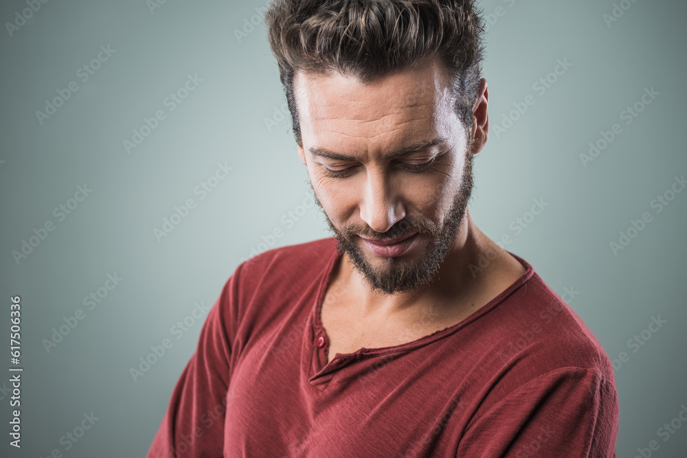Cool expressive young man looking down on gray background Cool expressive young man looking down on gray background