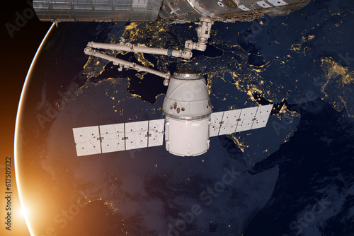 Fototapeta Naklejka Na Ścianę i Meble -  SpaceX Dragon orbiting the planet Earth. Elements of this image furnished by NASA.