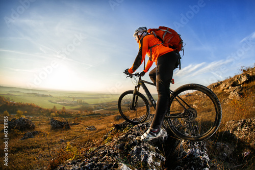 Foto A cyclist with a red backpack on a background of blue sky
