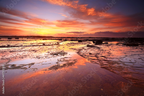 Sunrise skies reflecting on the exposed rock shelf at Long Reef  Northern Beaches  Australia