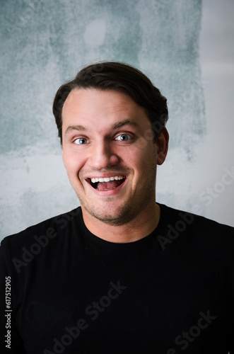 Portrait of young adult happy man against grunge wall © Designpics
