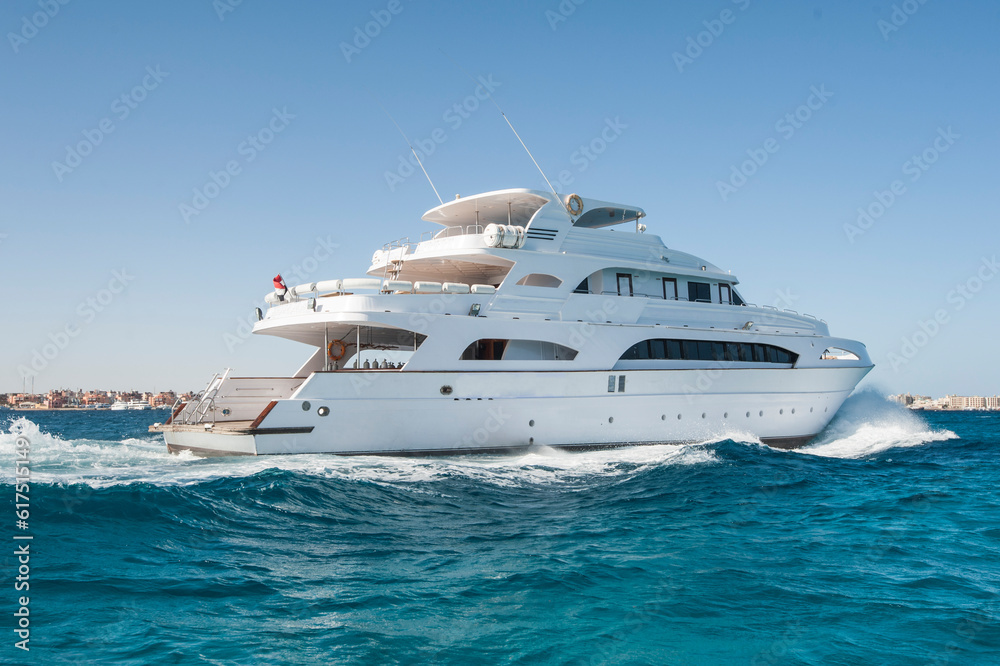 A large private motor yacht under way sailing out on tropical sea