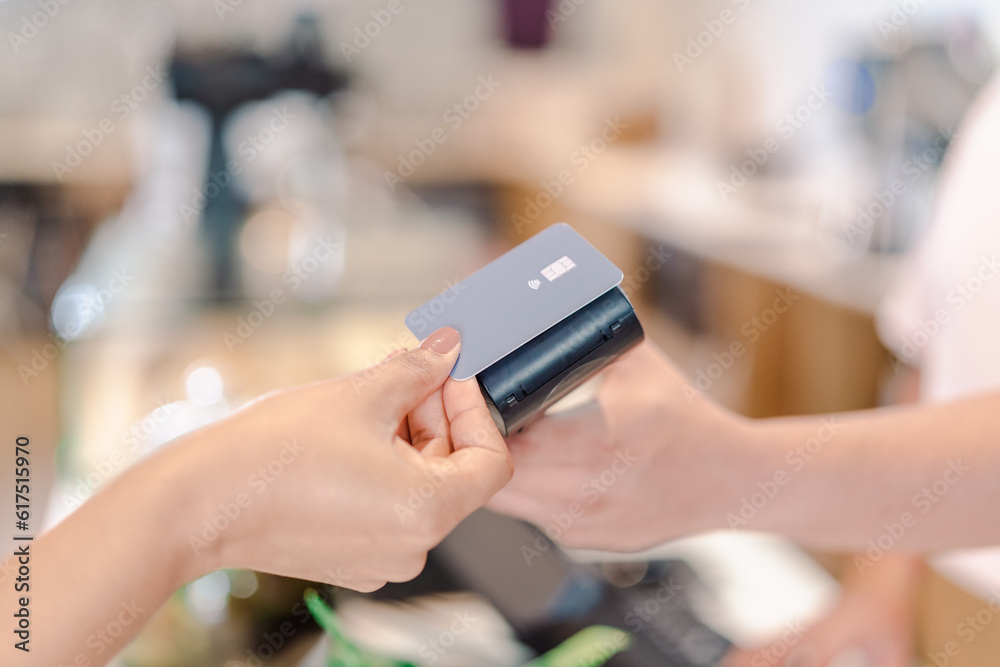detalhe da mão da cliente fazendo o pagamento da conta com cartão de crédito por aproximação em uma cafeteria no Brasil detalhe da mão da cliente fazendo o pagamento da conta com cartão de crédito por aproximação em uma cafeteria no Brasil