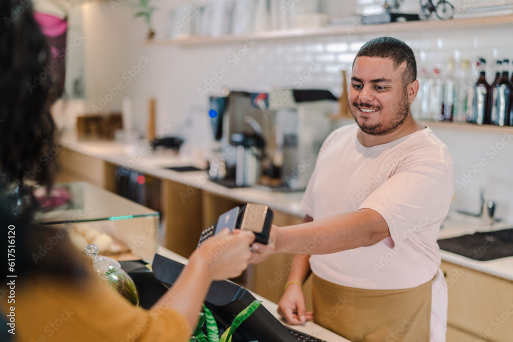 cliente Latina fazendo o pagamento da conta com cartão de crédito por aproximação em uma cafeteria no Brasil cliente Latina fazendo o pagamento da conta com cartão de crédito por aproximação em uma cafeteria no Brasil