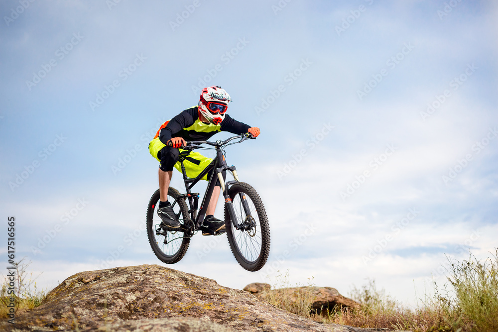 Professional Cyclist Riding the Bike Down Rocky Hill. Extreme Sport Concept. Free Space for Text. Professional Cyclist Riding the Bike Down Rocky Hill. Extreme Sport Concept. Free Space for Text.