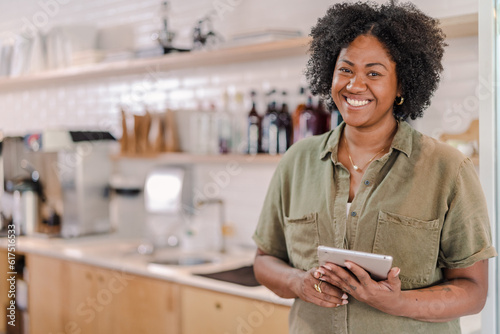 Latin coffee shop attendant smiling using a tablet to take a customer's order