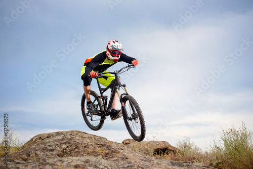 Fototapeta Naklejka Na Ścianę i Meble -  Professional Cyclist Riding the Bike Down Rocky Hill. Extreme Sport Concept. Free Space for Text.