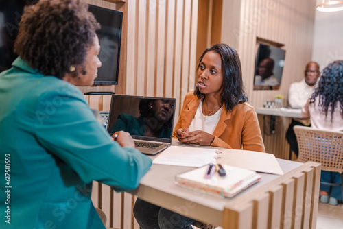 Fotografia Brazilian client discussing with her account manager the terms of her bank finan
