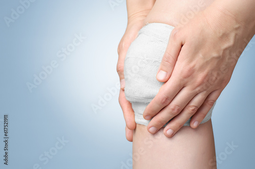 Injured painful knee with white gauze bandage