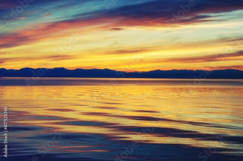 Beautiful gold and orange sunset above the sea and mountain © Designpics