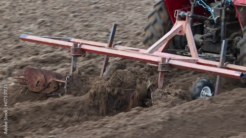 Homemade attachment harrow cultivator for mini tractor cultivated land in potato field.