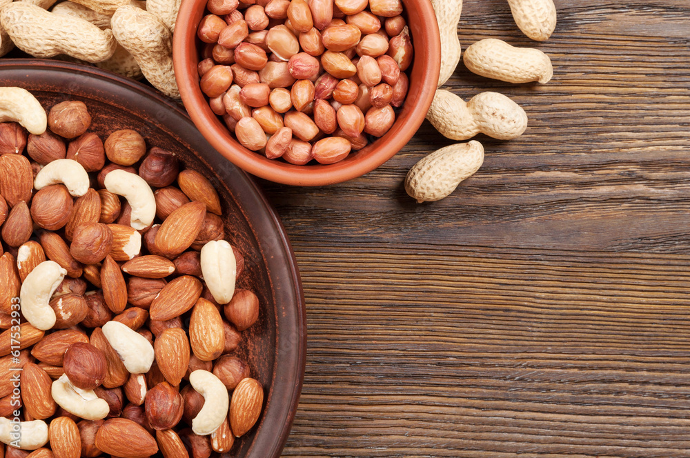 Different nuts in plates on a wooden background. Almond, hazelnut and cashew. Different nuts in plates on a wooden background. Almond, hazelnut and cashew.