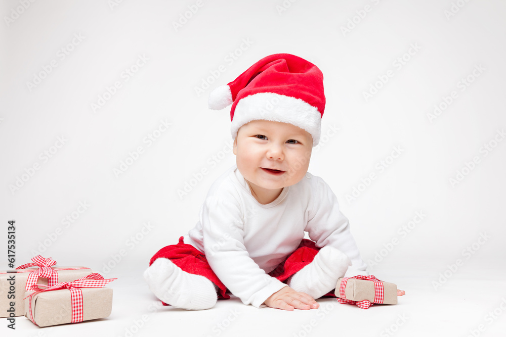 Adorable young baby boy wearing a Santa hat opening Christmas presents Adorable young baby boy wearing a Santa hat opening Christmas presents