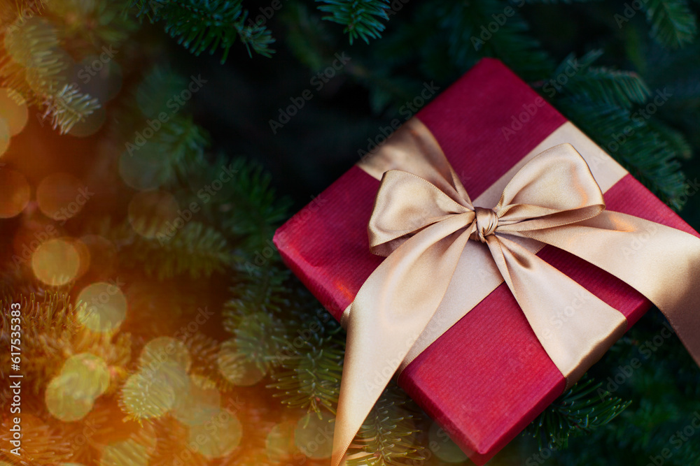 nicely wrapped gift by christmas tree with lights, toned image nicely wrapped gift by christmas tree with lights, toned image