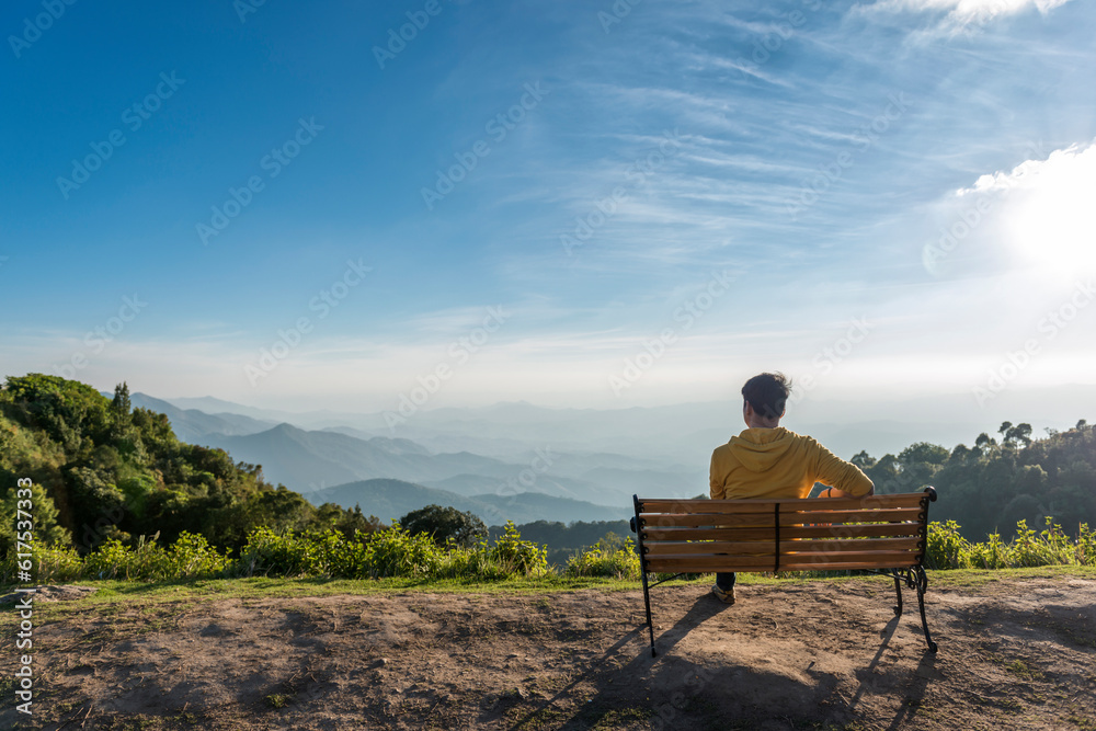 Traveler man siting wooden bench with Mountains background ,Doi Inthanon Thailand Traveler man siting wooden bench with Mountains background ,Doi Inthanon Thailand