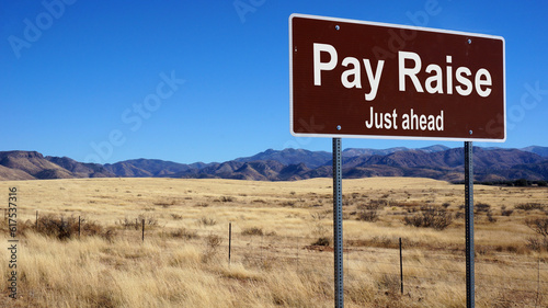 Pay Raise road sign with blue sky and wilderness