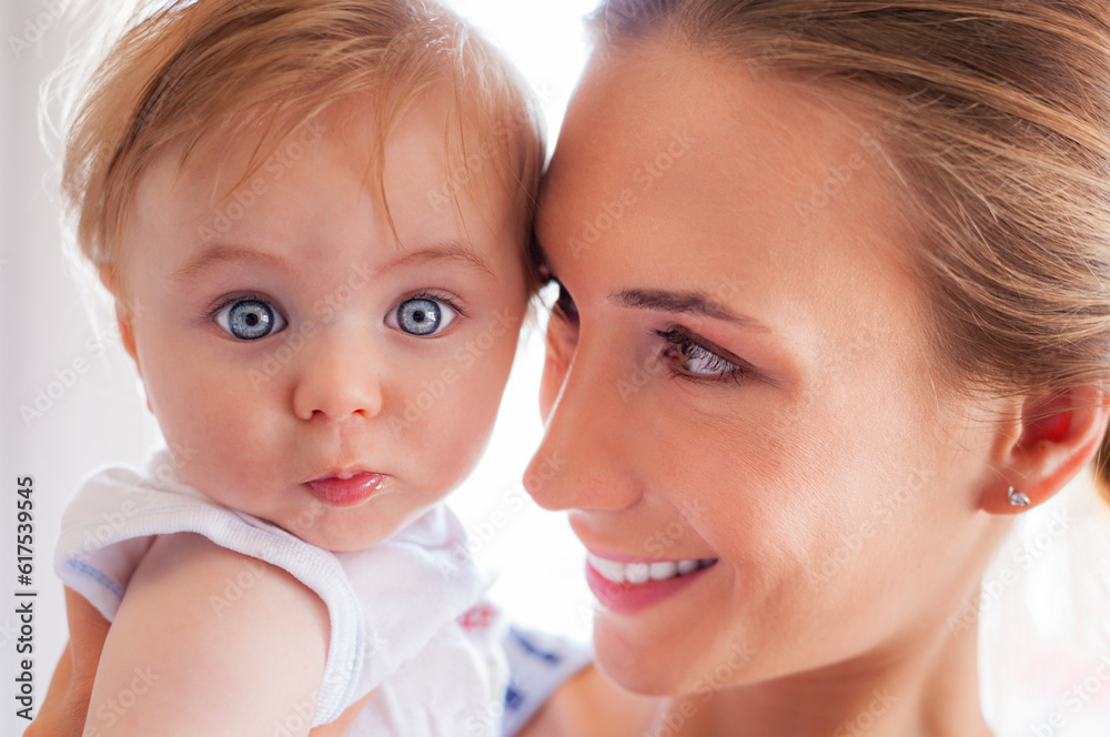 A beautiful young mother embracing her little baby boy with big curious eyes. A beautiful young mother embracing her little baby boy with big curious eyes.