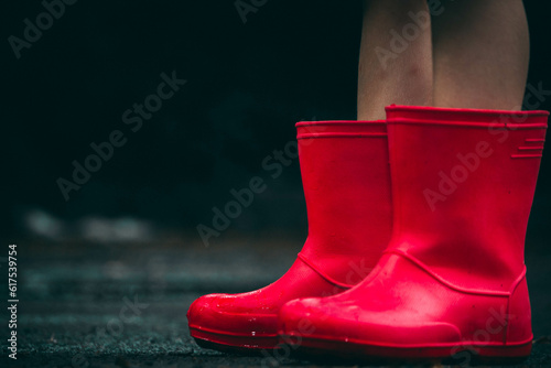 child in red rubber boots