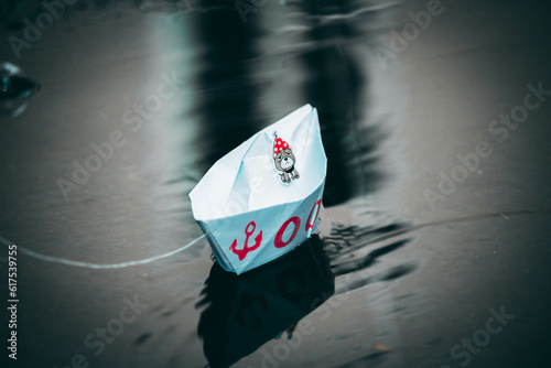 paper boats are standing on the street in a puddle