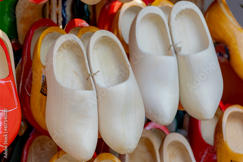Souvenir business concept, Selective focus of white brown wooden shoe hanging the shelf and display on souvenir shop, Clogs are a type of footwear made in part or completely from wood.