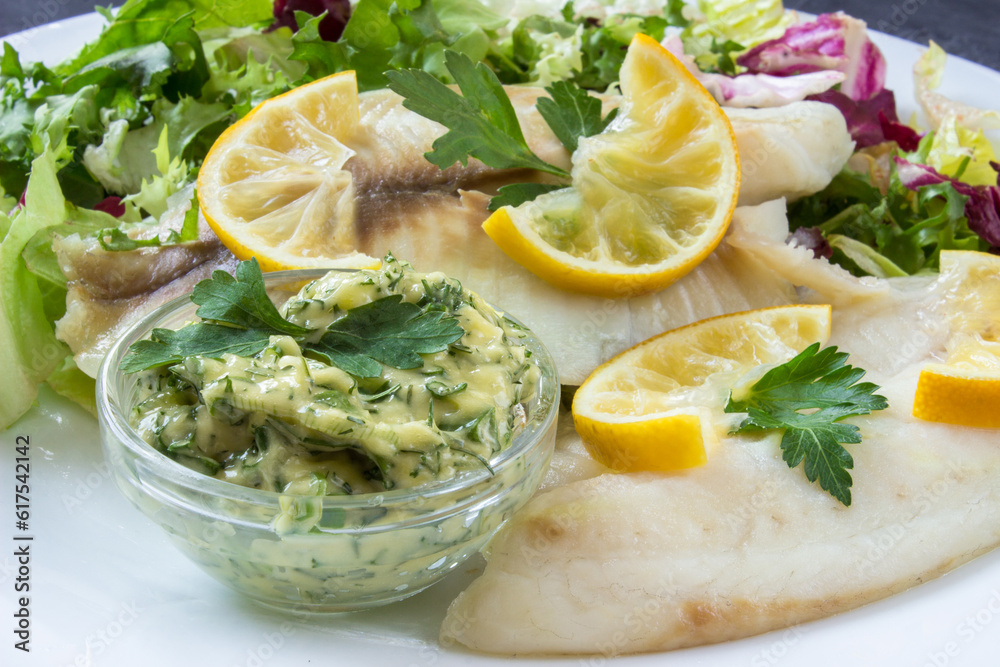 steamed tilapia fish with salad, slices of lemon and tartar sauce steamed tilapia fish with salad, slices of lemon and tartar sauce