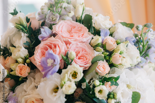 Wedding decor. Beautiful bouquet with white and pink roses and green leaves, closeup
