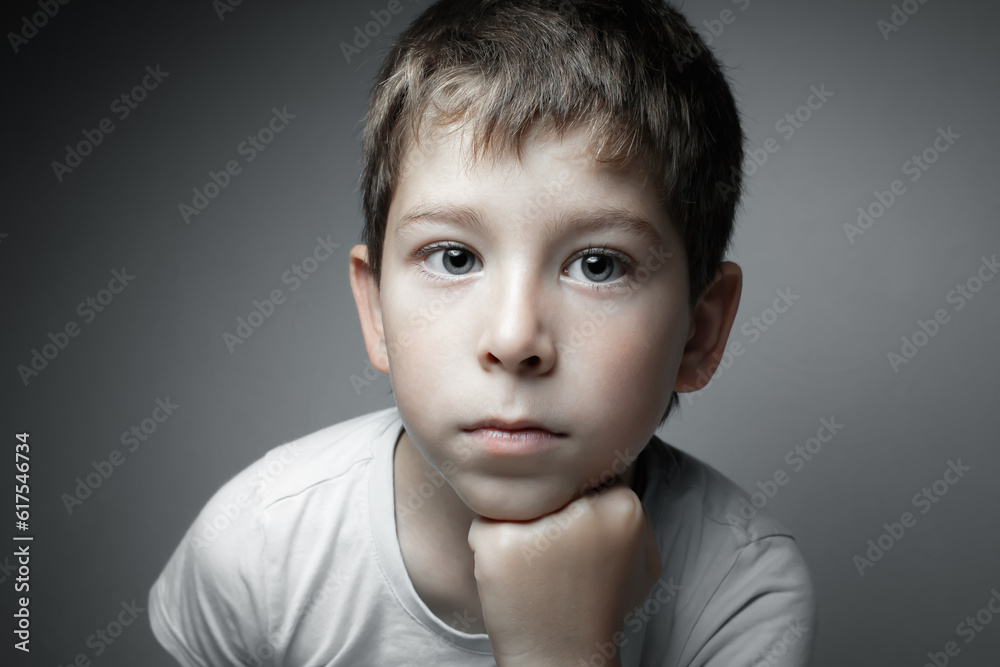 Portrait of a handsome boy looking in cam. Isolated on the gray background