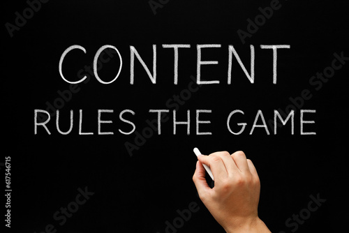 Hand writing Content Rules The Game with white chalk on blackboard.