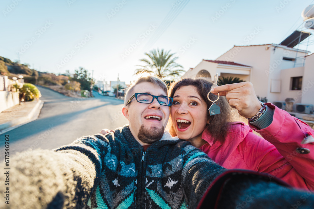 real estate: couple showing keys of their new house