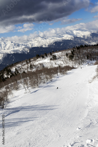 Skiers on ski slope at sun winter day. Caucasus Mountains. Hatsvali, Svaneti region of Georgia.