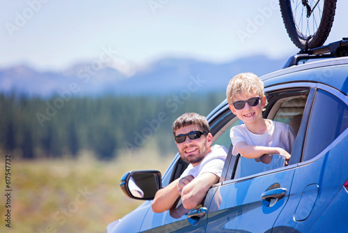happy family of two, young father and his son, looking out of the car enjoying road trip and active vacation together © Designpics