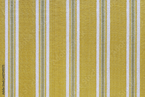 Natural linen texture as background. Cotton fabric with yellow and white line striped pattern, texture close up. Backdrop, wallpaper. Matereal for clothes, curtain and upholstery