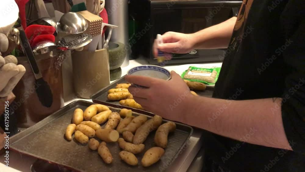 young man preparing baked fingerling potatoes in the kitchen young man preparing baked fingerling potatoes in the kitchen