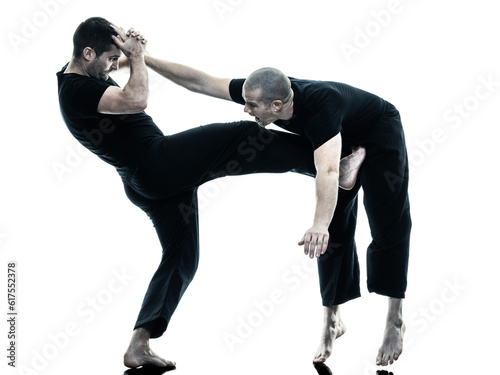 two caucasian men krav maga fighters fighting isolated silhouette on white background photo