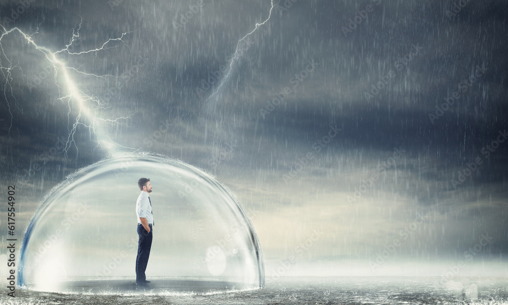 Businessman safely inside a sphere during a storm . Protection from the crisis concept Businessman safely inside a sphere during a storm . Protection from the crisis concept