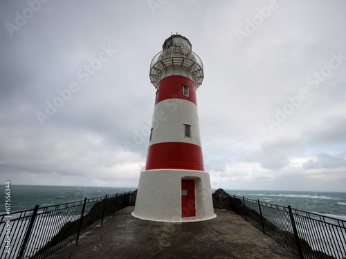 Fotografia Panorama view of red and white stripes lighthouse on top of oceanside cliff hill