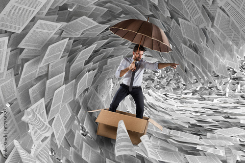 Concept of the storm of bureaucracy with a man sailing in a carton in the sea of sheets photo