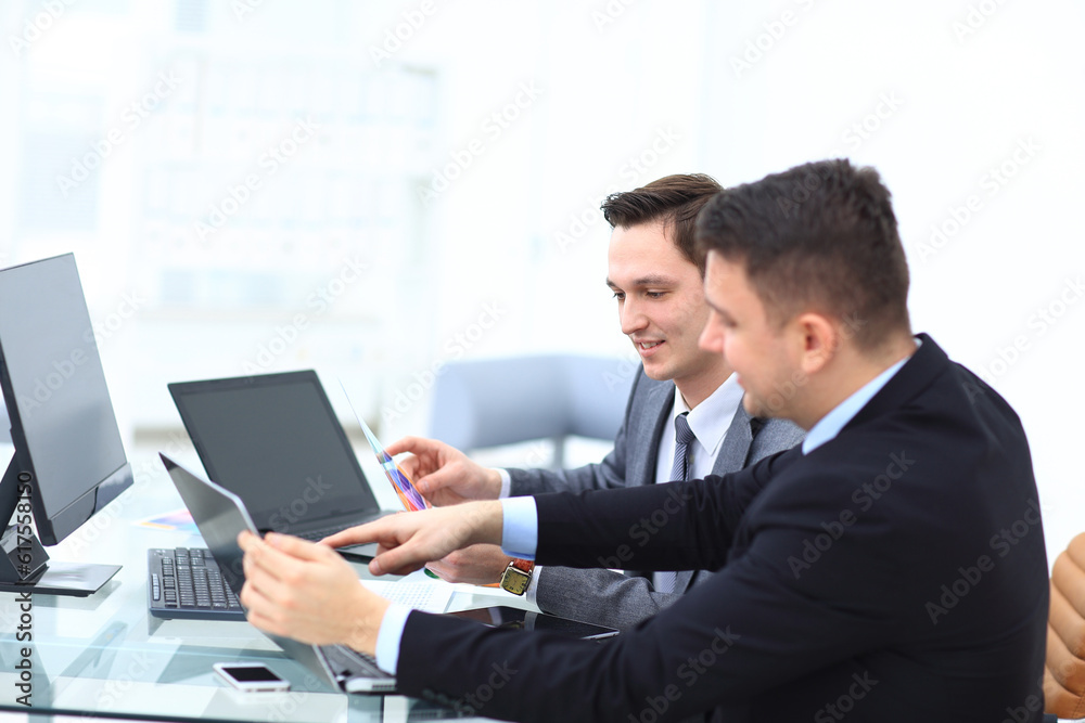 Two colleagues businessman discussing data and digital tablet and computer laptop with smart phone with digital business strategy on wooden desk as concept Two colleagues businessman discussing data and digital tablet and computer laptop with smart phone with digital business strategy on wooden desk as concept