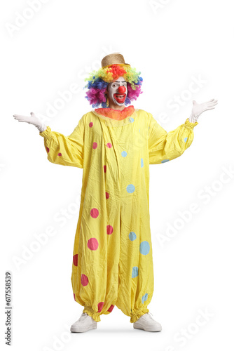Full length portrait of a clown in yellow costume gesturing welcome with hands