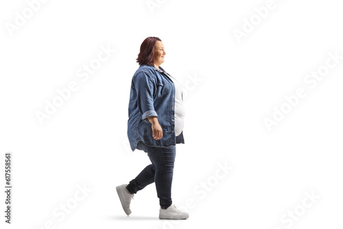 Full length profile shot of an overweight young woman in casual clothing walking