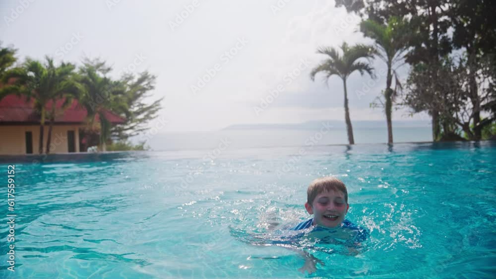 Boy Smiling While Swimming At Infinity Pool Boy Smiling While Swimming At Infinity Pool