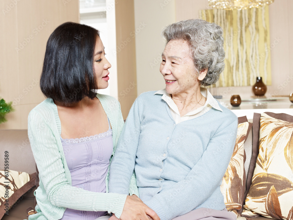 senior asian mother chatting with adult daughter at home senior asian mother chatting with adult daughter at home