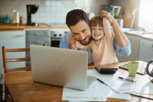 Young father and daughter using a laptop together in the morning
