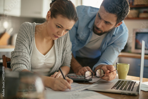 Young couple going over their bills at home in the kitchen