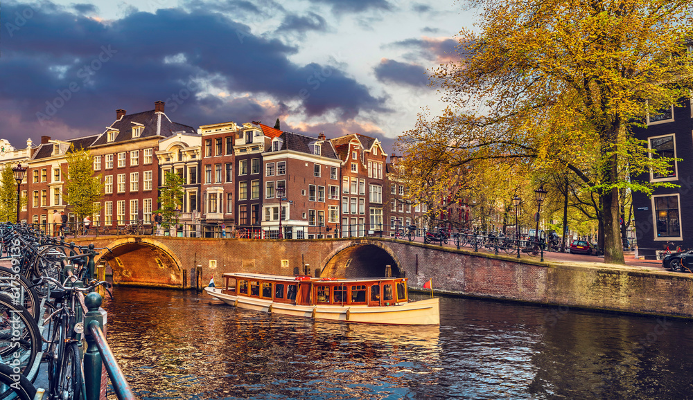 Channel in Amsterdam Netherlands Holland houses under river Amstel. Landmark old european city spring landscape with sunshine.