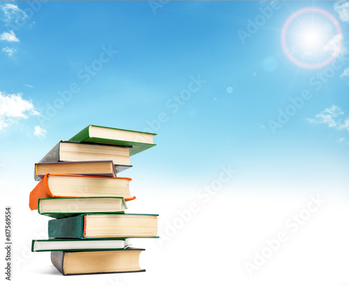 A stack of books on white floor against blue sky. Education concept