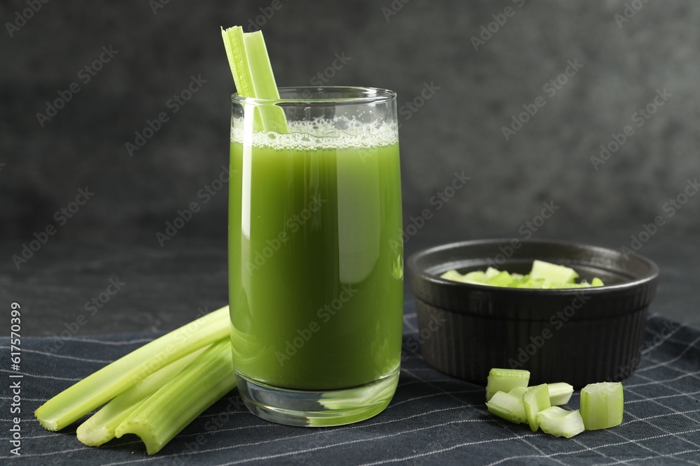 Glass of delicious celery juice and vegetables on table, closeup Glass of delicious celery juice and vegetables on table, closeup