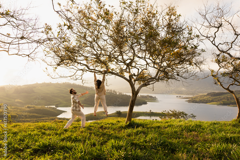 Obraz premium woman hangs from a tree and her boyfriend shows it to her